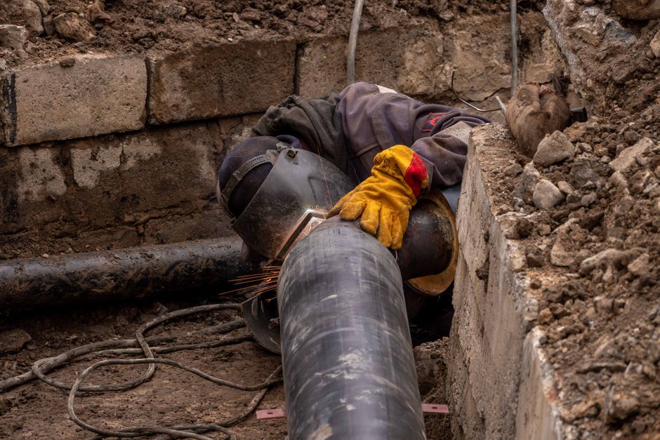 Close-up of a drainage pipe undergoing inspection with tools in a West Sussex garden